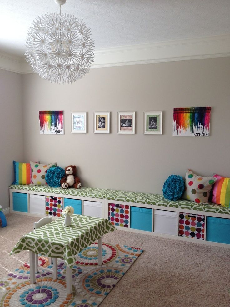 a room with some colorful furniture and pictures on the wall above it's windows