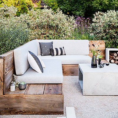 an outdoor seating area with white couches and wooden pallets in the foreground