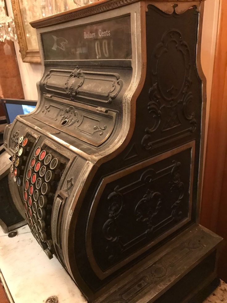 an old fashioned cash register sitting on top of a marble counter next