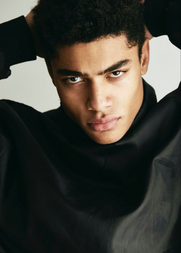 A Close Up Of A Person Wearing A Black Shirt And Holding His Hands On a-close-up-of-a-person-wearing-a-black-shirt-and-holding-his-hands-on