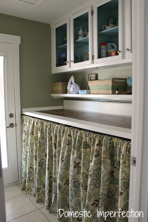 DIY laundry room on a budget - raised chicken wire cabinets, counter made from leftover wood flooring and trim, curtains to hide washer and dryer.