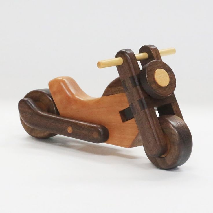 a wooden toy motorcycle on a white background