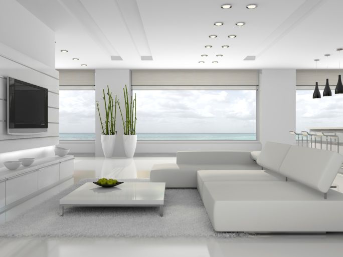 a modern living room with white furniture and plants in the vase on the coffee table