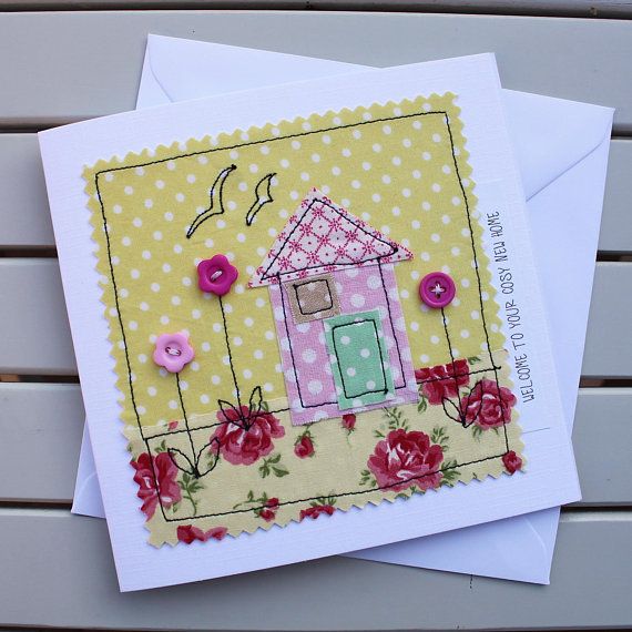 two greeting cards, one with a house and the other with flowers on it are sitting next to each other