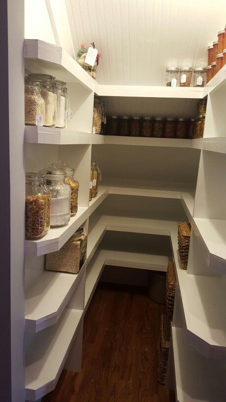 an empty pantry filled with lots of food and condiments on white shelving