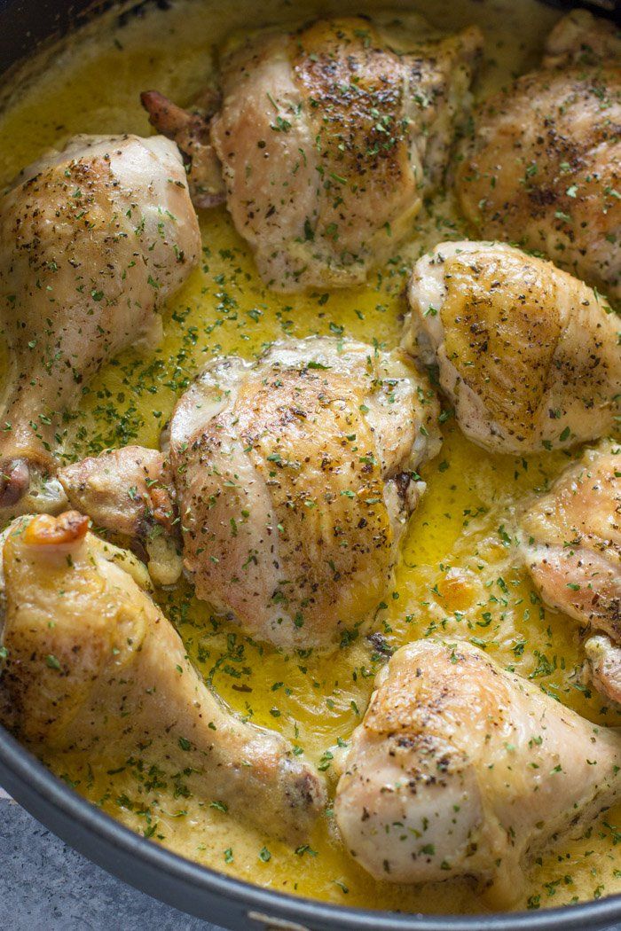 some chicken is cooking in a pot with yellow sauce and herbs on top, ready to be cooked