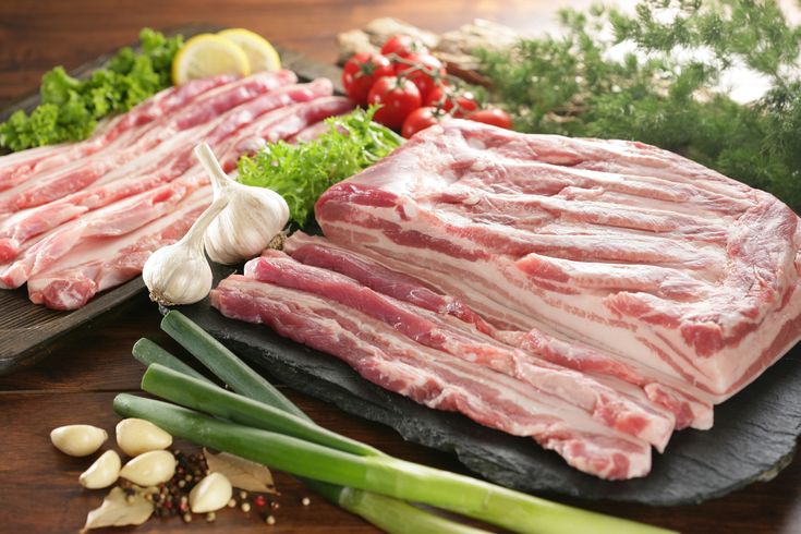 This may contain: raw meats and vegetables are laid out on the table to be prepared for cooking This may contain: raw meats and vegetables are laid out on the table to be prepared for cooking