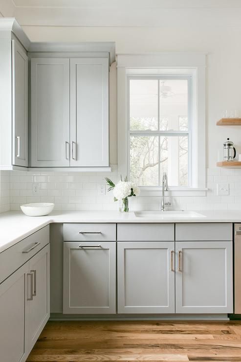 A Single Window In Transitional Kitchen Surrounds Dove Gray Shaker A Single Window In Transitional Kitchen Surrounds Dove Gray Shaker Cabinets With Floating Wood Shelves
