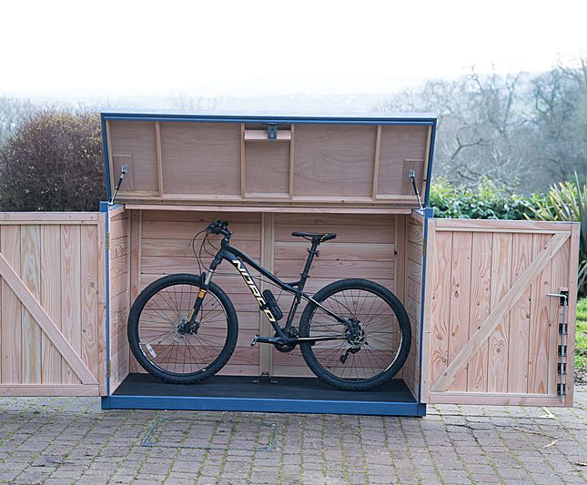 a bicycle is parked in the back of a wooden box