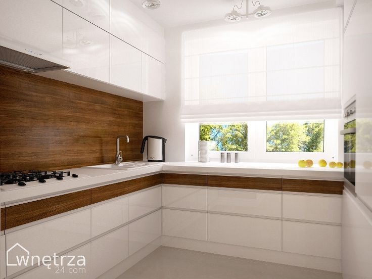 an empty kitchen with white cabinets and wood paneling on the counter top, along with a window