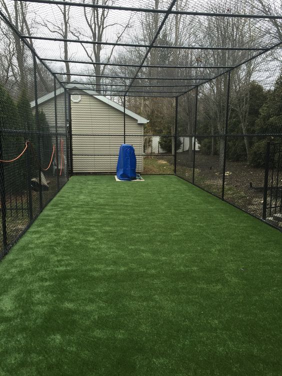 the inside of a fenced in backyard with artificial grass