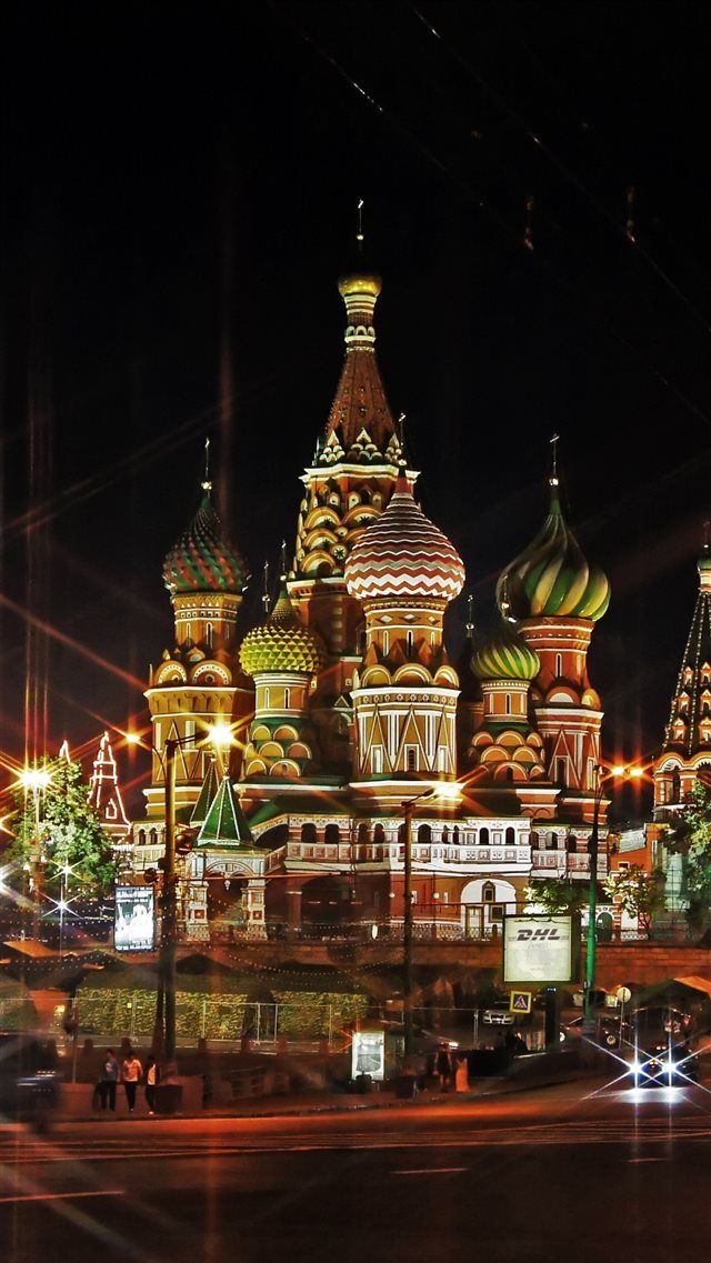 the cathedral is lit up at night with bright lights on it's domes and spires