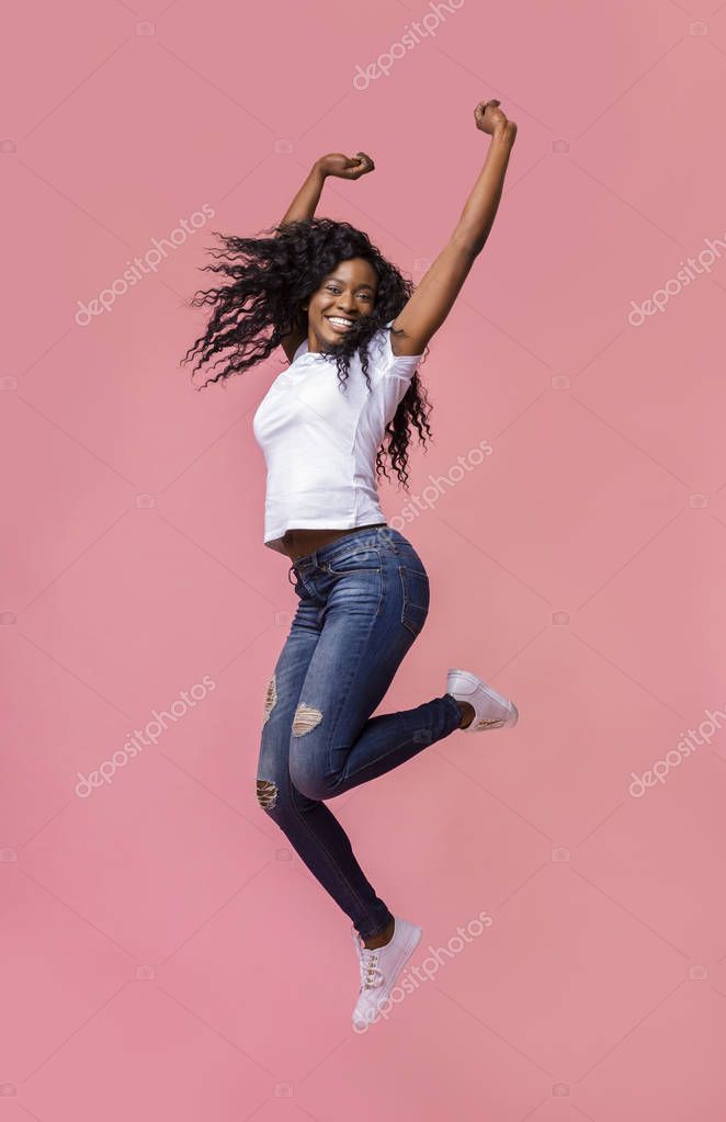 Smiling Young African Woman Jumping In Air Stock Photo