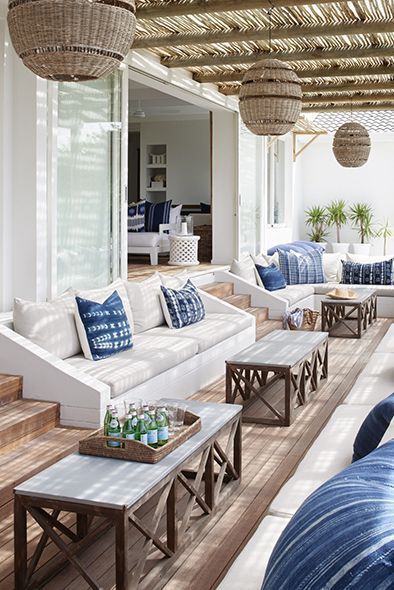 a living room filled with white couches and lots of blue pillows on top of it