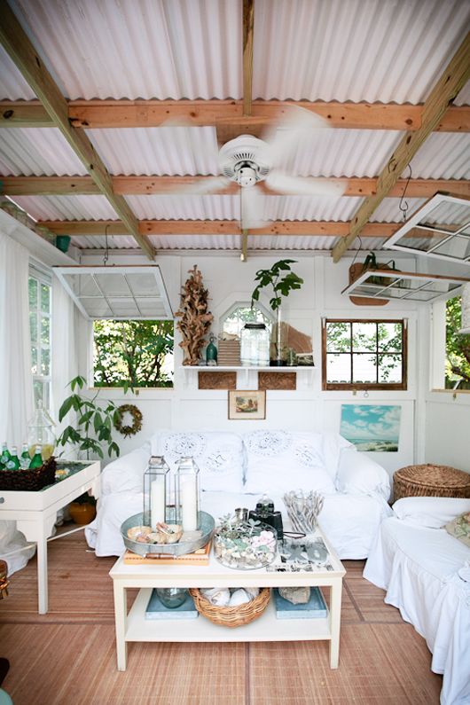 a living room filled with white furniture and lots of wood flooring on top of it