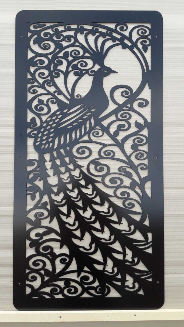 This may contain: an intricately designed metal panel with a peacock on it