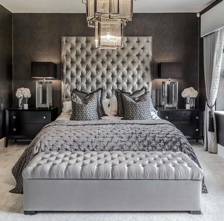 a bedroom with black and white decor, chandelier and bed