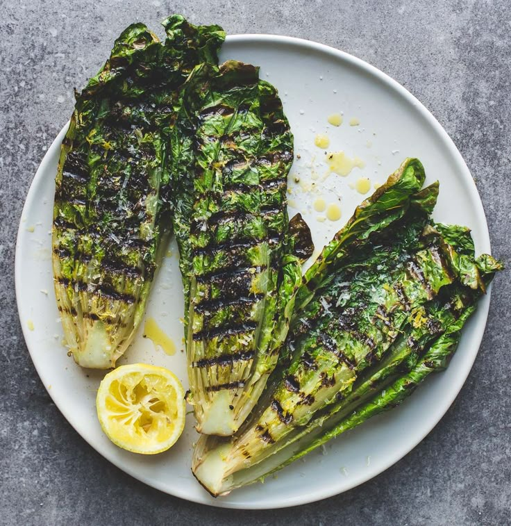 grilled fish on a plate with lemon wedges