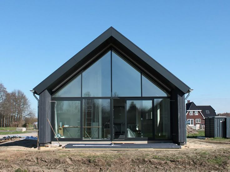 a black house sitting on top of a dirt field