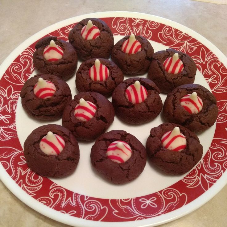Fun holiday chocolate thumbprint cookies top with a white chocolate peppermint kiss. These Christmas cookies are family friendly, easy to make and so delectable. Fun holiday chocolate thumbprint cookies top with a white chocolate peppermint kiss. These Christmas cookies are family friendly, easy to make and so delectable.