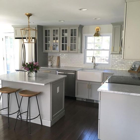 Gray Kitchen Features Shaker Cabinets Adorned With Br Gray Kitchen Features Shaker Cabinets Adorned With Br Pulls By Lewis Dolan Paired Honed Carrera Marble Countertops And A White Mini Subway Tile