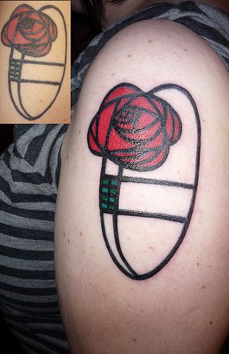 a woman with a tattoo on her arm has a red flower in the shape of a heart