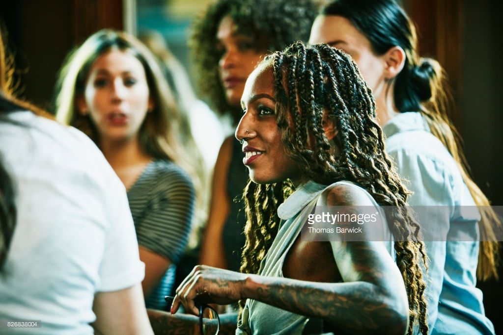 Stock Photo Smiling woman in discussion with friends in