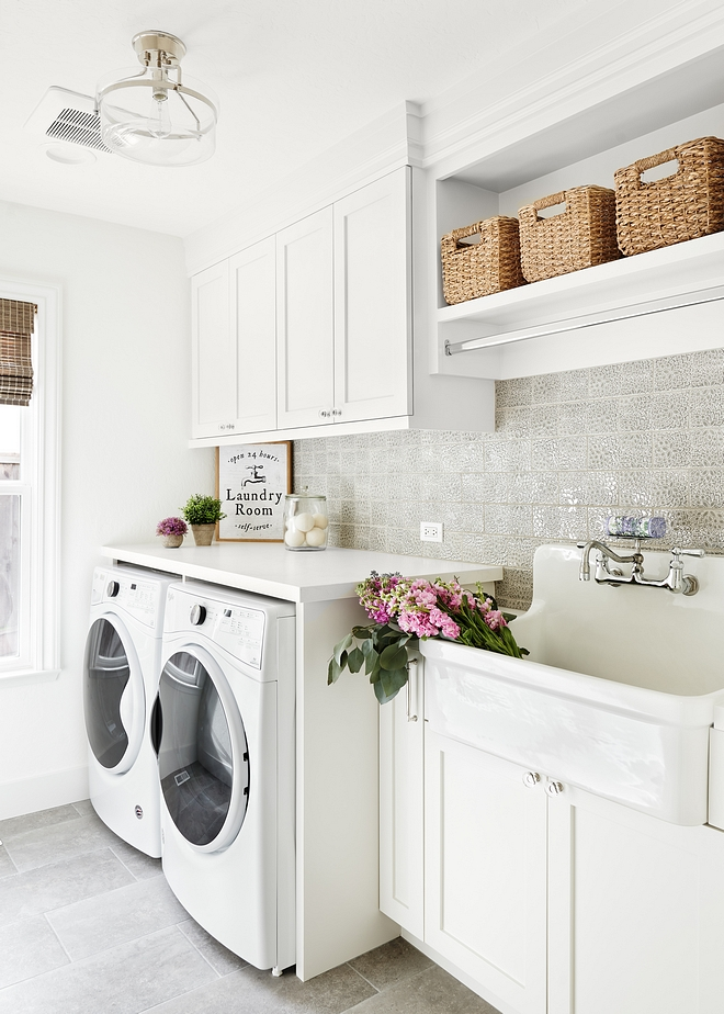 Laundry room Featuring custom white cabinets and an utility sink, this