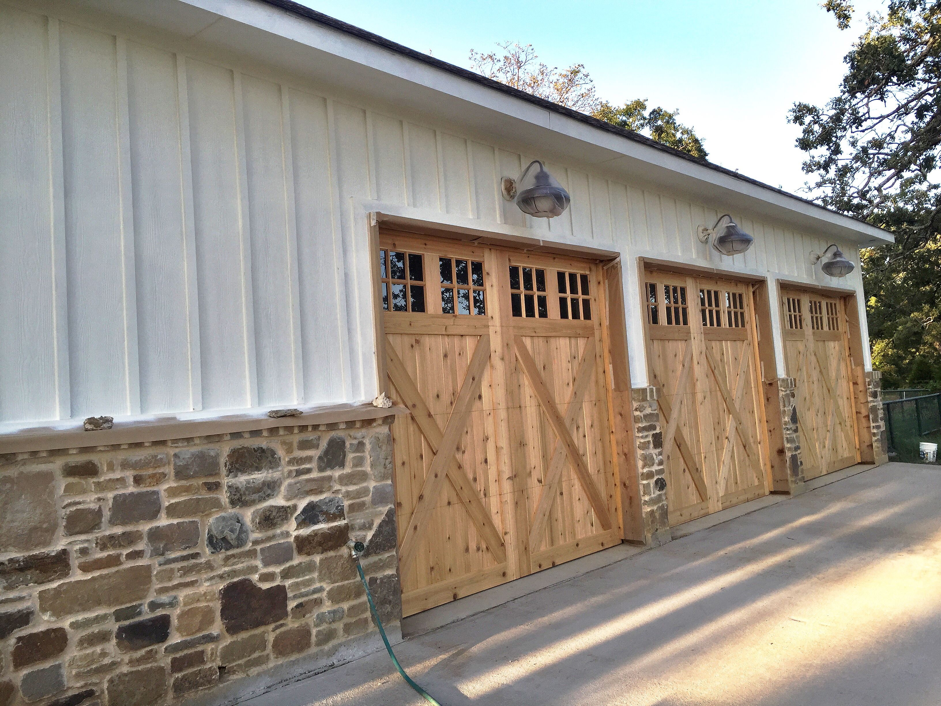 Custom Cedar Crossbuck garage doors before stain, farmhouse style