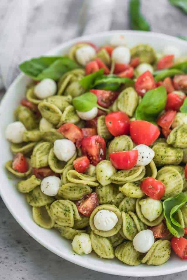 The ultimate summer potluck dish, this caprese pasta salad is made with chunks of pearl mozarella, juicy cherry tomatoes and tossed in a bright pesto sauce! Potluck Dishes, Potluck Recipes, Side Dish Recipes, Pasta Dishes, Dinner Recipes, Healthy Recipes, Salada Caprese, Caprese Pasta Salad, Pasta Salad Recipes