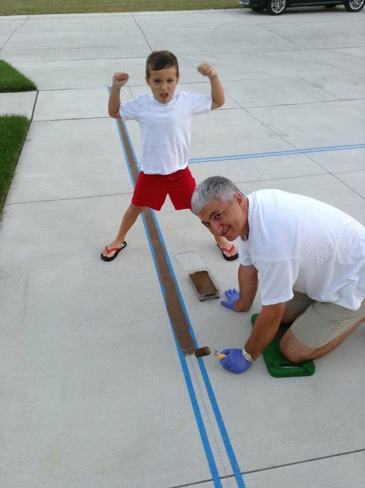 Kazem And His Son Tape Down A Two Inch Baseline And Roll On Brown Paint For Their New Driveway Bask Backyard Basketball Basketball Court Backyard Boys Learning