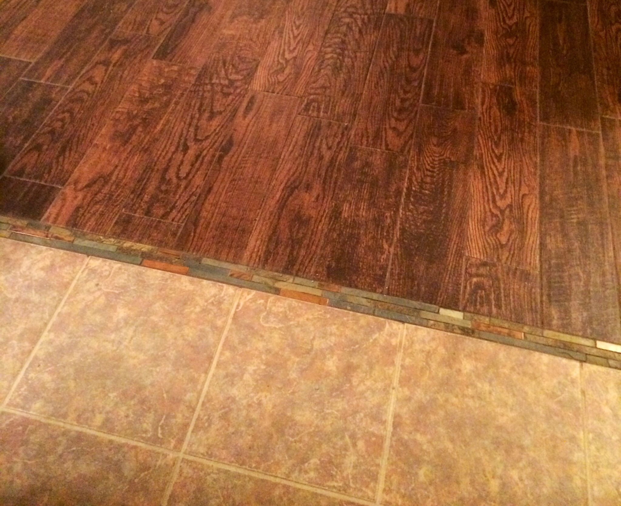 Tile to wood tile transitioned using mosaic tile between the two
