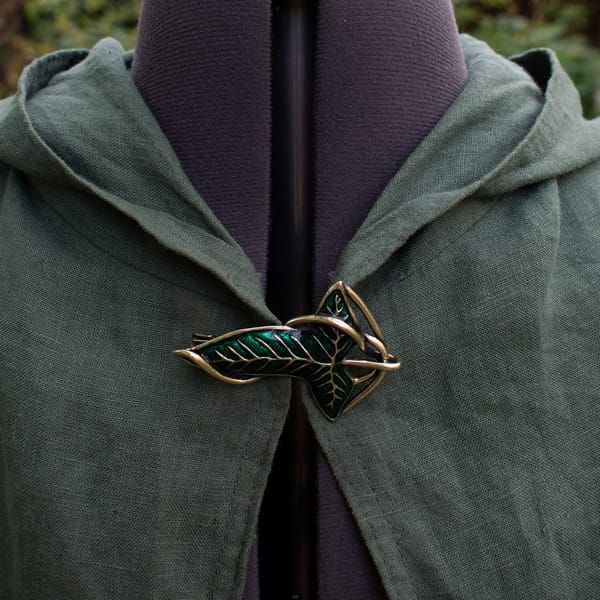 the back of a green jacket with a leaf brooch on it the back of a green jacket with a leaf brooch on it