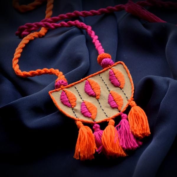 This designer necklace set will add to your beauty in any outfit, especially ethnic. The spiritual motif of Ganesha or Gajaraj, the God of wisdom and new beginnings, is painted at the centre of the pendant and earrings. This set is bound to make you the centre of attraction and attention in the best way possible. Diy Fabric Jewellery, Fabric Earrings, Thread Jewellery, Textile Jewelry, Handmade Jewelry Designs, Embroidery Jewelry, Crochet Jewelry, Tribal Jewelry, Crochet Necklace