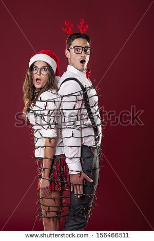 Funny Nerd Couple Are Tangling In Christmas Lights Stock Photo