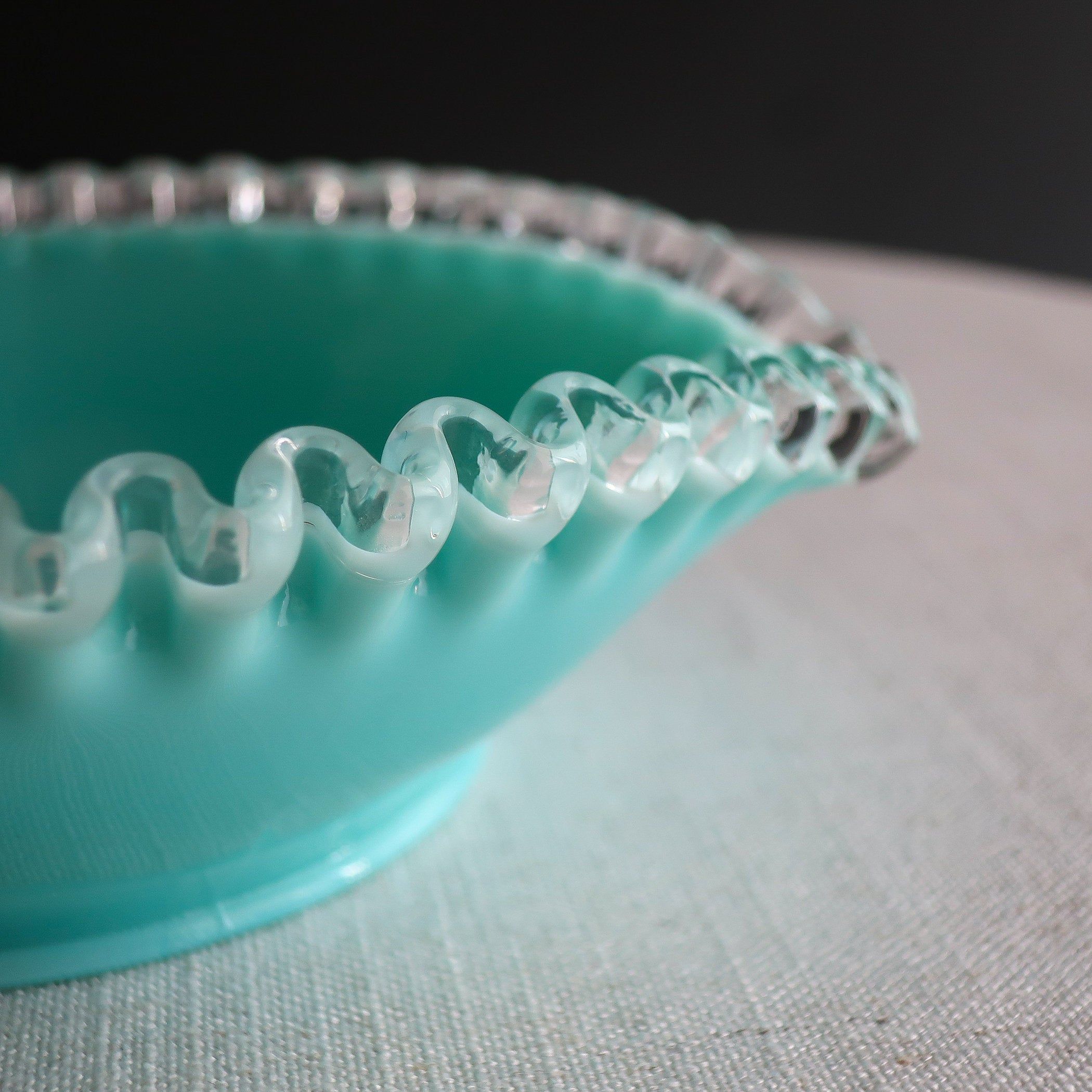 Heart or leaf-shaped blue milk glass bowl with small handle made by Fenton. This turquoise color was produced with the clear glass band at the rim only between 1956 and 1959. Measures about 3 1/8 inches high to top of handle, 8 inches wide, 7 1/8 inches deep. Unmarked. Overall condition is good, with no chips, cracks or repairs, but there is a small dark streak within the glass on the side of the bowl. To see other milk glass items in my shop, click here: http://www.etsy.com/shop/JeniSandbergVin