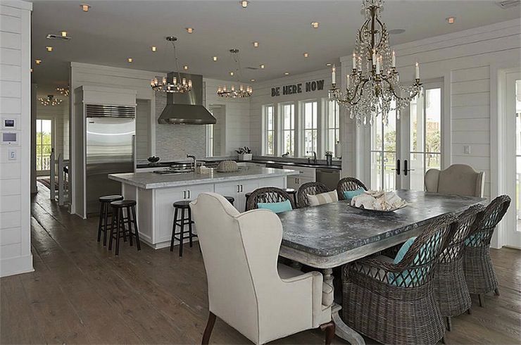 Beach Cottage Kitchen With Crystal Chandelier Over Whitewashed Beach Cottage Kitchen With Crystal Chandelier Over Whitewashed Dining Table Zinc Top Surrounded By Wicker Chairs And Wingback Captain