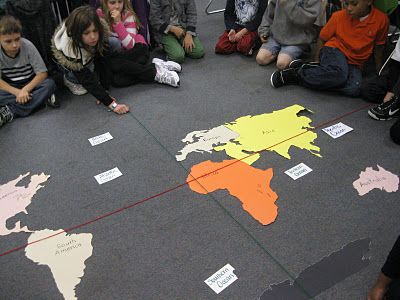 Hands on geography!! The teacher is reviewing latitude, longitude - new world map with equator and prime meridian lines Hands on geography!! The teacher is reviewing latitude, longitude - new world map with equator and prime meridian lines