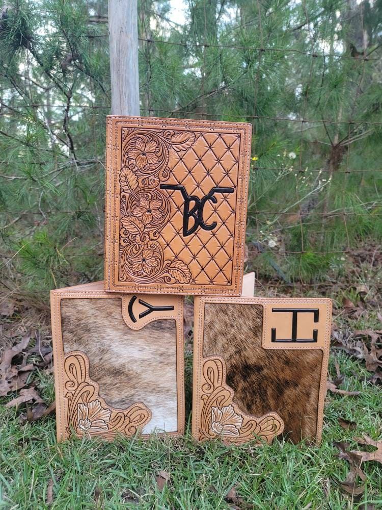 Custom leather padfolio, notebook cover. Business card slot, pen holder, and paper pad sleeves make this the one staple for all your business needs. Great way to put your brand, logo or name front and center. Great gift for a college student, a new job, or business venture! Fully custom, the designs have no limits! Message from pricing on customs. Lead time average 10-12 weeks. Leather Bible Cover, Leather Notebook Cover, Notebook Covers, Custom Leather Work, Leather Working, Western Themed Wedding, Leather Padfolio, Leather Tooling Patterns, Cowhide Handbags