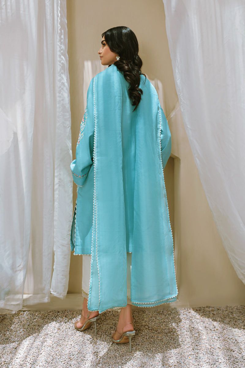 This frosty blue A-line shirt is cut with an overlapping neckline and straight sleeves, both of which boast Champa embroidery and mirror work detailing. A rounded, embroidered pocket is also added to further enhance the look, whilst the delicate laces help complete it. This piece is paired with an organza dupatta. Piec Pakistani Designers, Pakistani Dress Design, Pakistani Dresses, Stylish Dress Designs, Stylish Dresses, Punjabi Bride, Pure Cotton, Organza, Designer Dresses