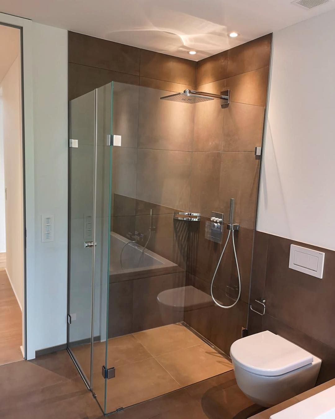Badezimmer in warmen Brauntönen mit eleganter ebenerdiger Dusche Badezimmer in warmen Brauntönen mit eleganter ebenerdiger Dusche