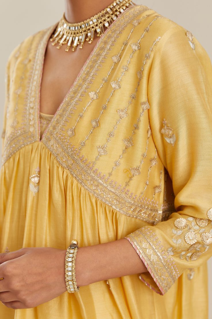Yellow silk chanderi kurta with all-over gold gota and zari embroidery and embroidered cotton slip inside. It has ‘V’ neck and fine gathers at empire line. Sleeves are 3/4 highlighted with embroidery. Emroidered, Cotton Slip, Zari, Bell Sleeve Top, Women Wear, Sleeve Length, Silk, Yellow, Empire