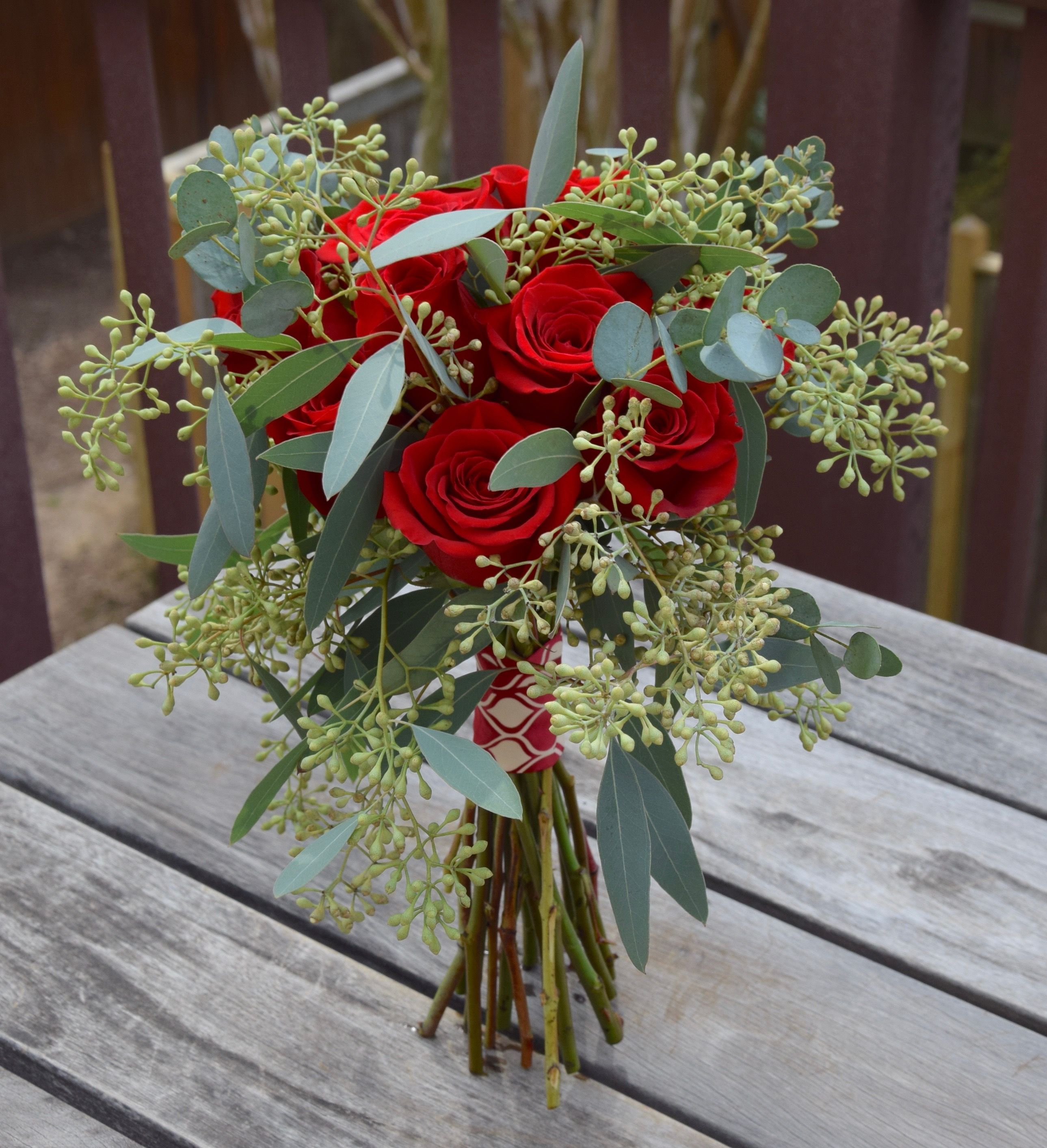 Dozen red roses with seeded eucalyptus handtied bouquet Fiori
