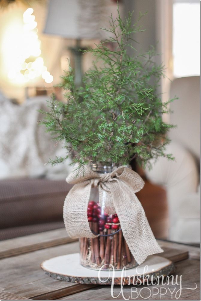 Simple holiday table centerpiece evergreen in a glass vase filled with