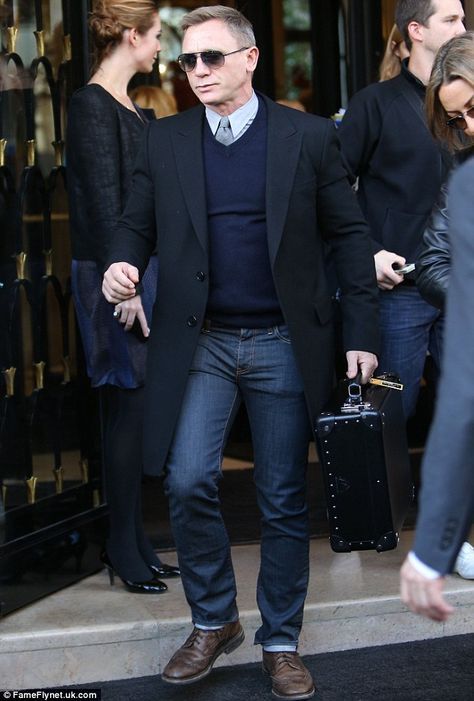 Daniel Craig looks stuck in 007 character as he leaves Paris hotel