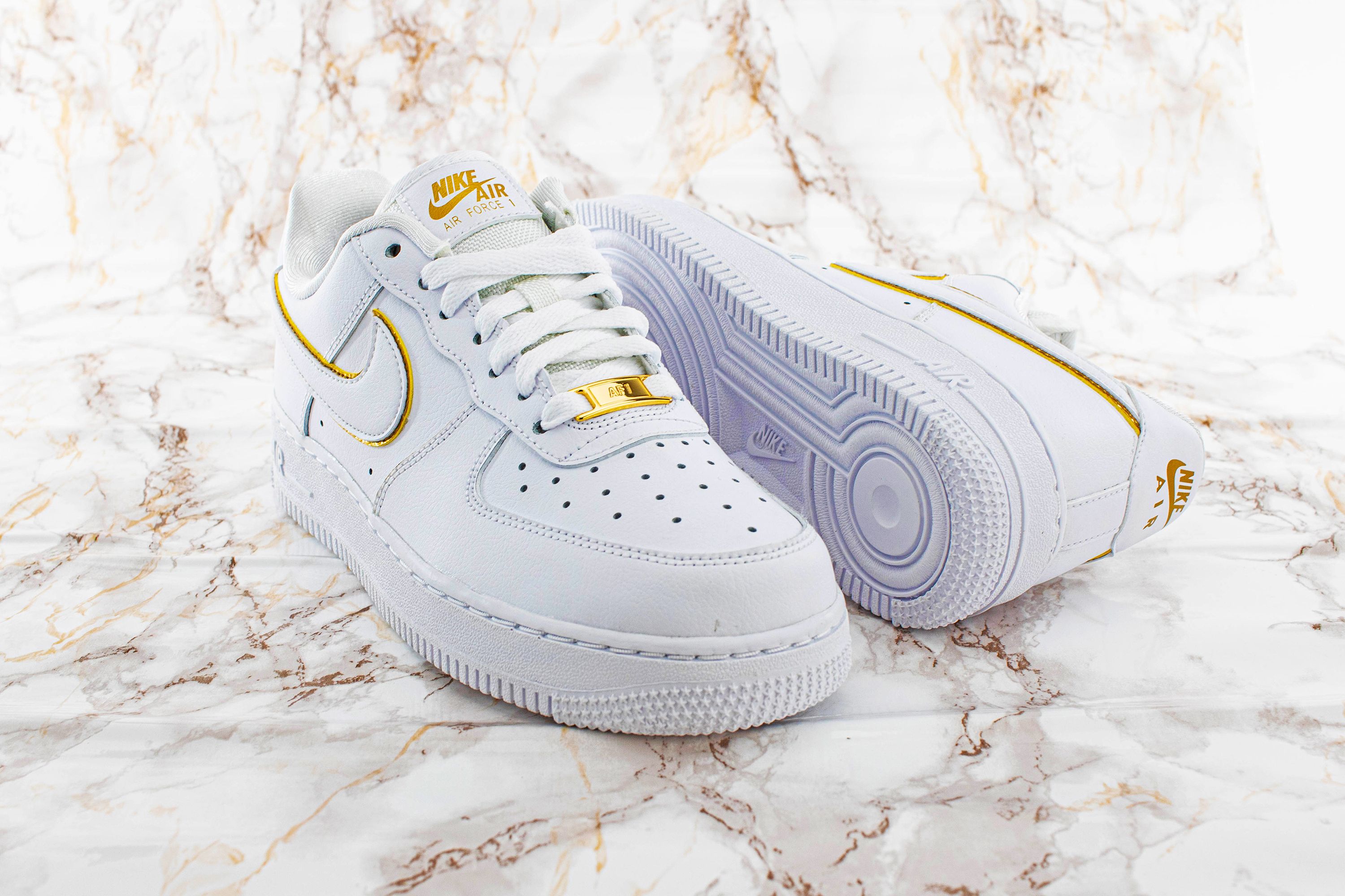 The Nike Air Force 1 07 Essential in white with golden