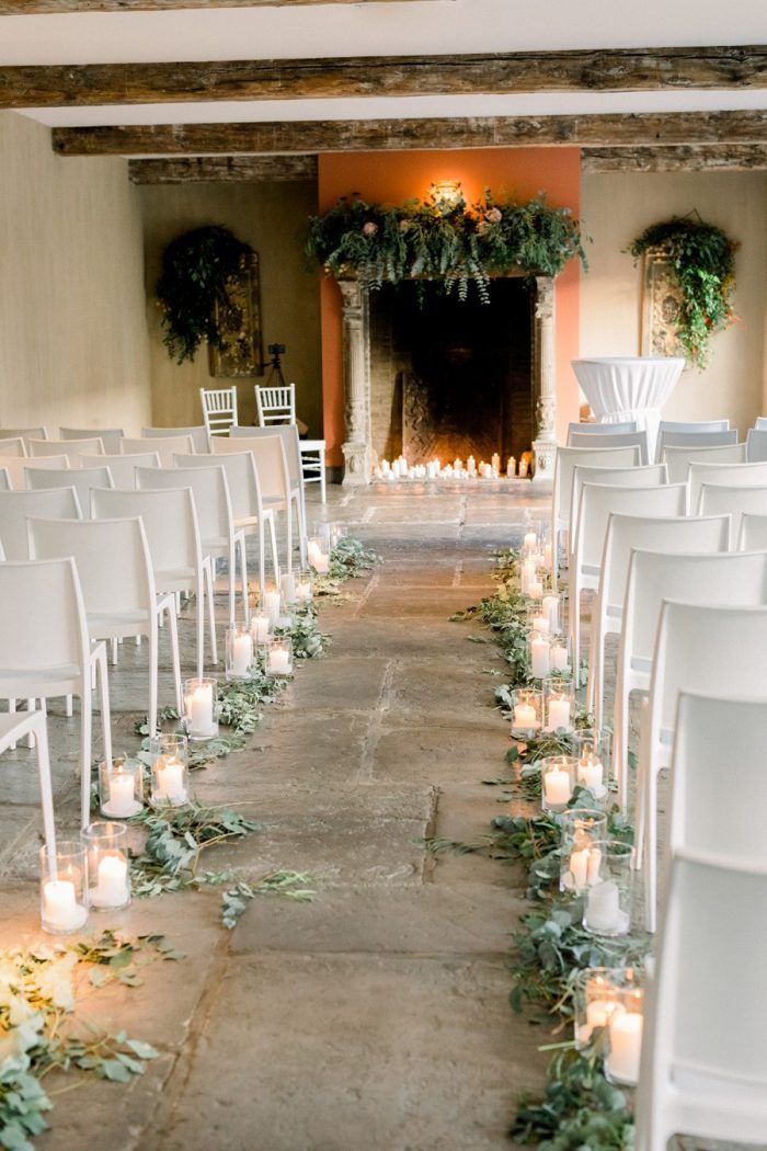 Scattered eucalyptus and candles in vases lining the outside ends of each row