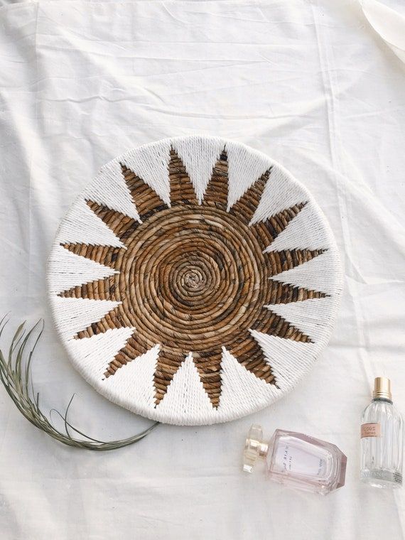 Decorazione murale sospesa a trama naturale realizzata in corteccia di banana, corda bianca e telaio in ferro. Caratteristica con tessuto a mano con lartigiano locale con design a stella rotonda. Perfetto per decorare la tua casa, per la tua decorazione murale Boho, la decorazione del soggiorno, il Bohemian Style Gifts, Bohemian Wall Decor, Wall Decor Set, Boho Chic Decor, Hanging Wall Decor, Boho Style, Woven Basket Wall Decor, Basket Wall Art, Baskets On Wall