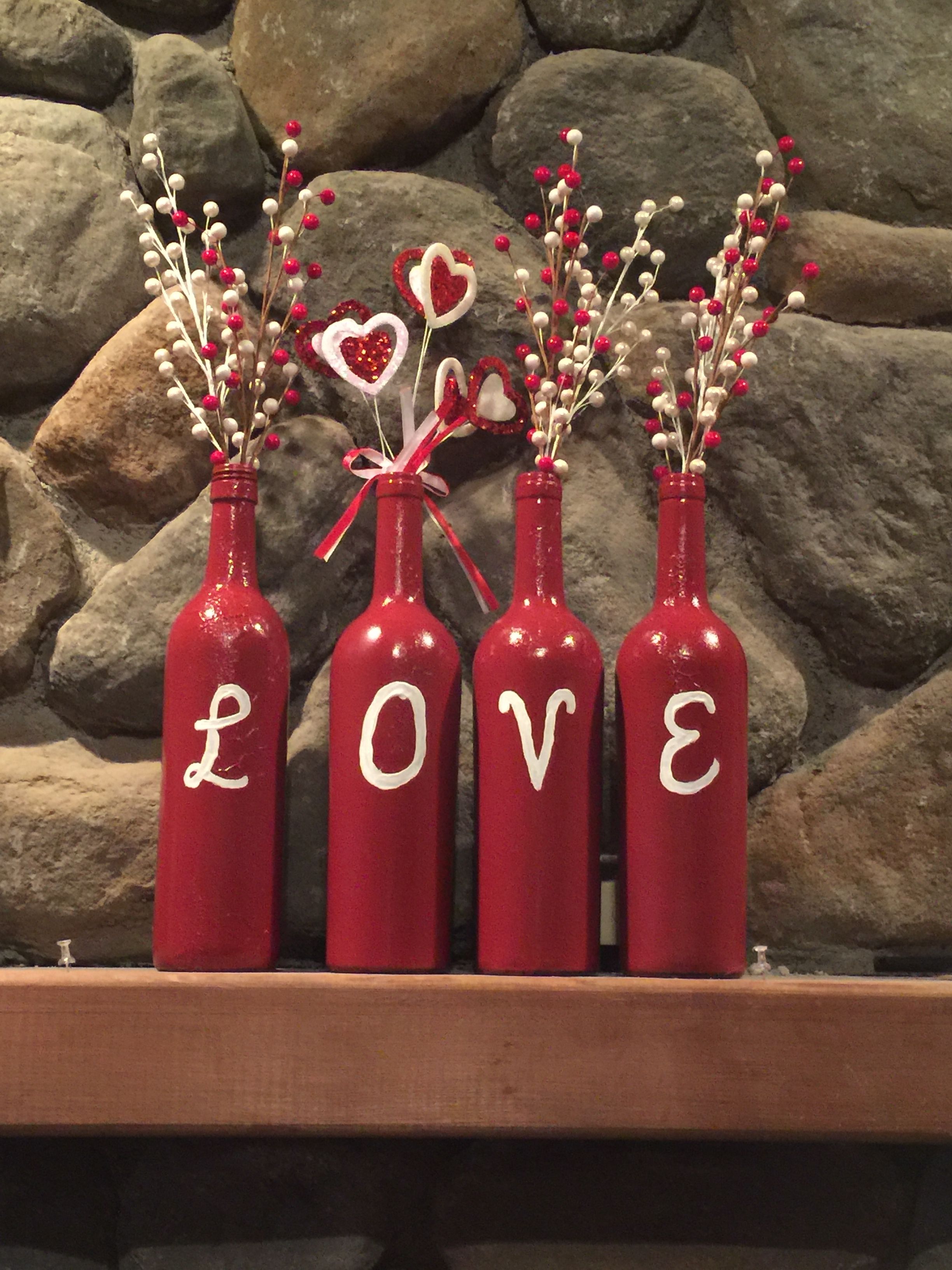 four red wine bottles with love written on them and flowers in the
