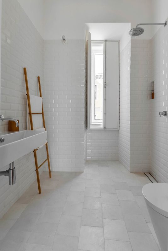 White tiles — hydraulic ones on the floor and “biselado” (meaning “beveled”) ones on the walls — make for a tranquil bathroom. White Bathroom Tiles, White Subway Tiles, Bathroom Floor Tiles, Laundry In Bathroom, White Bathrooms, Shower Tiles, Vanity Bathroom, Bright Bathroom, Concrete Bathroom